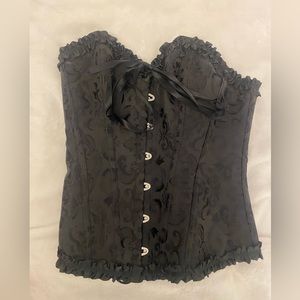 black corset with design on it and black ruffles size small